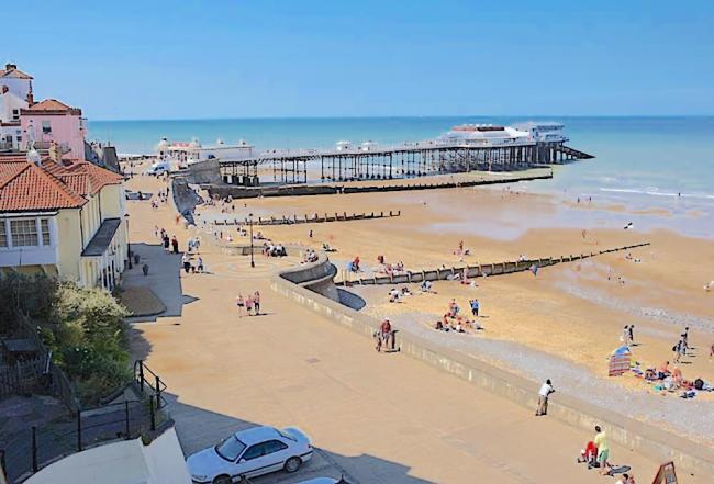 Discover Fabulous Beaches Along The North Norfolk Coast. Cromer's sandy beach and pier at low tide.
