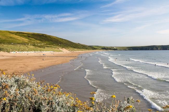 View Large and Small Town and Country Cottages Within a 15-minute Drive of the Coast. Surfing waves roll in to a long sandy beach backed by sand dunes.