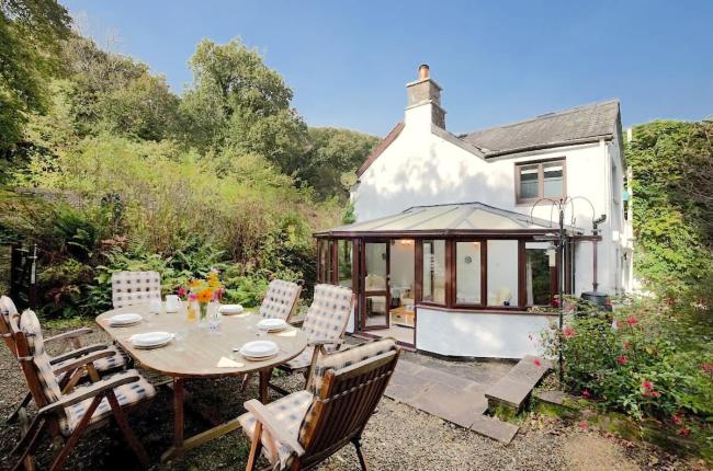 Book North Devon Holiday Cottages in Parkham Close to the Coast. A rural North Devon holiday cottage and garden with a patio table laid for tea.