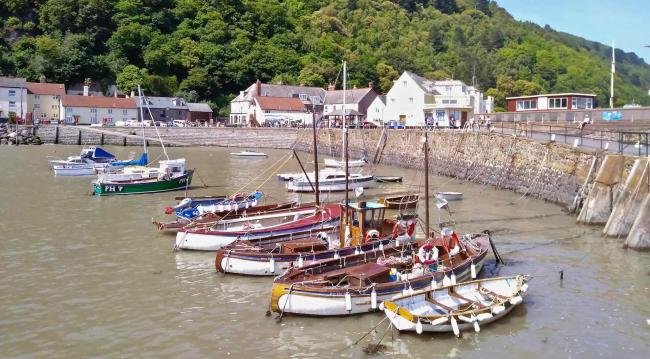 View Seaside Holiday Cottages in Minehead. Fishing boats and small craft moored in rows in Minehead harbour