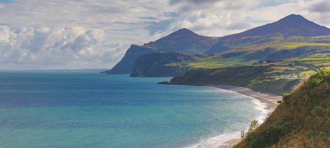 A coastline of silhouted promentaries extending into the sea.