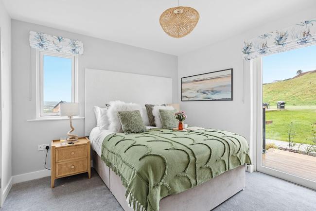 A large bedroom with a comfortable bed over looking green fields in Woolacombe.