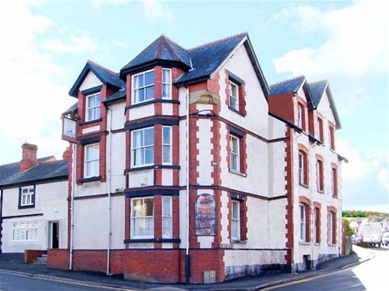Exterior of a large 3-Victorian Inn  on a street corner, now converted into a big holiday cottage.