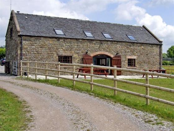 A stone-built barn conversion overlooks a lawned garden.