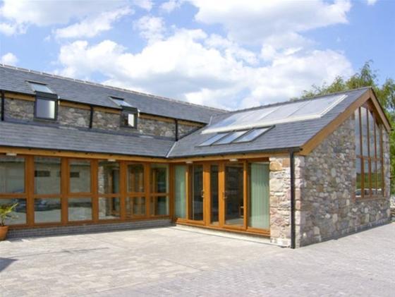 A contemporary cottage with floor-to-ceiling windows facing a courtyard