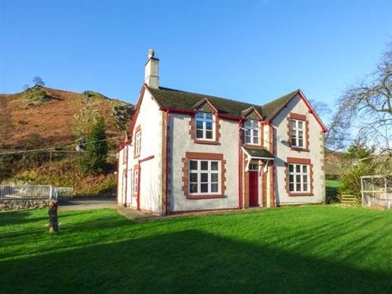 A double-fronted 2-storey house with a large lawn in a moorland location