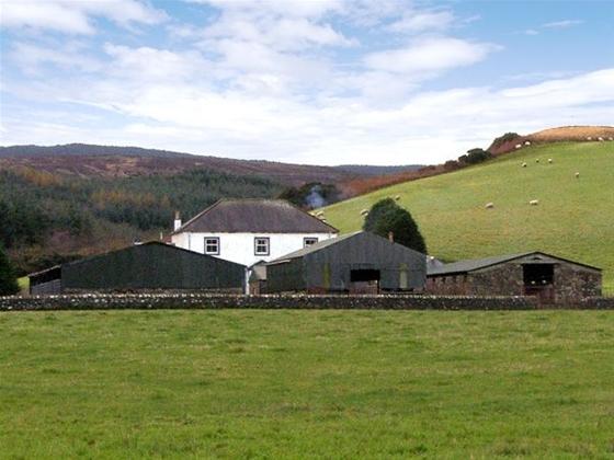 A Northumberland farmhouse in open countryside overlooks a row of traditional barns