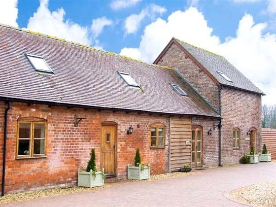 A brick-built barn conversion overlooks a block-paved courtyard in Shropshire.