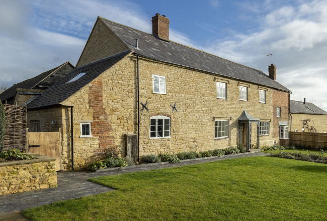 Large, stone-built farmhouse with a spacious lawn.