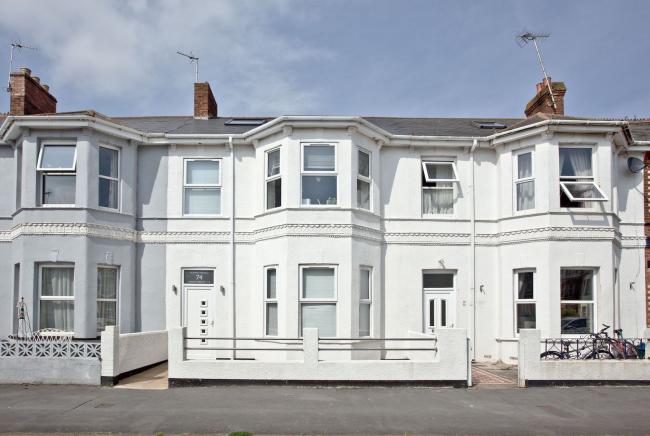 A terraced row of well-maintained Victorian Houses with small low-walled front garden.
