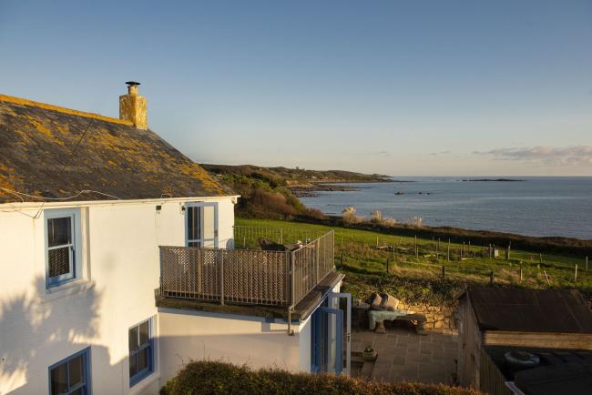 A two storey Marazion holiday cottage overlooks a lawned garden and sweeping sea views.
