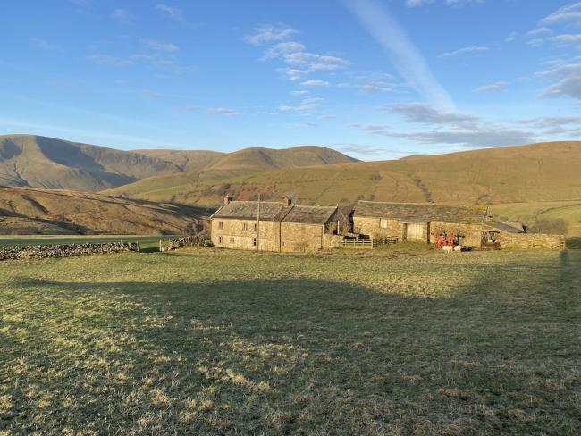 A stone-built Cumbrian farmhouse and attached barns in a remote moorland location
