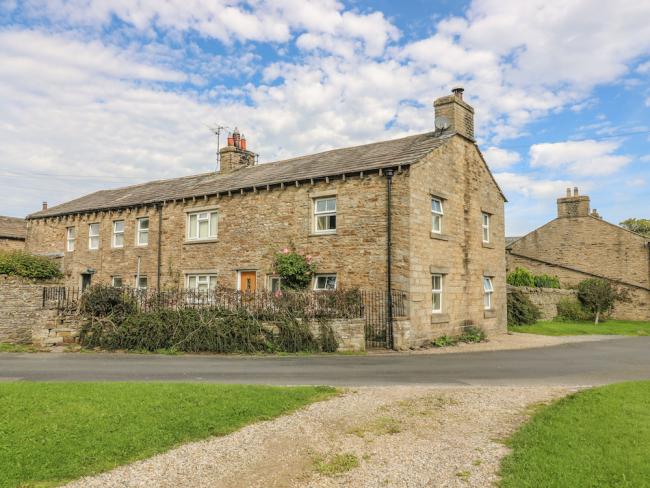 A row of three stone-built cottages with walled gardens.