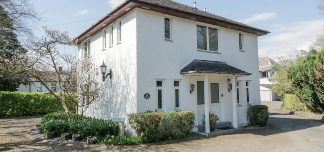 A detached period housewith a pillared portico entrance is surrounded by a mature garden.
