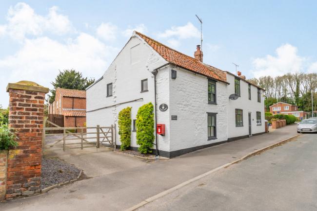 Exterior of a semi-detached holiday cottage in East Yorkshire overlooking a quiet road with plenty of parking spaces to the rear.