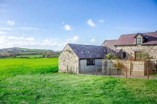 Exterior of a rural holiday cottage in Abersoch surrounded by green fields