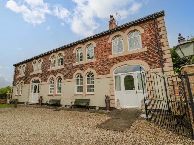 Exterior of The Old Power House converted to a large, 2-storey holiday cottage with two rows of five double windows.