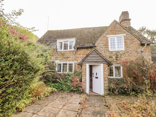 2-storey stone-built Cotswold Cottage surrounded by a mature garden.