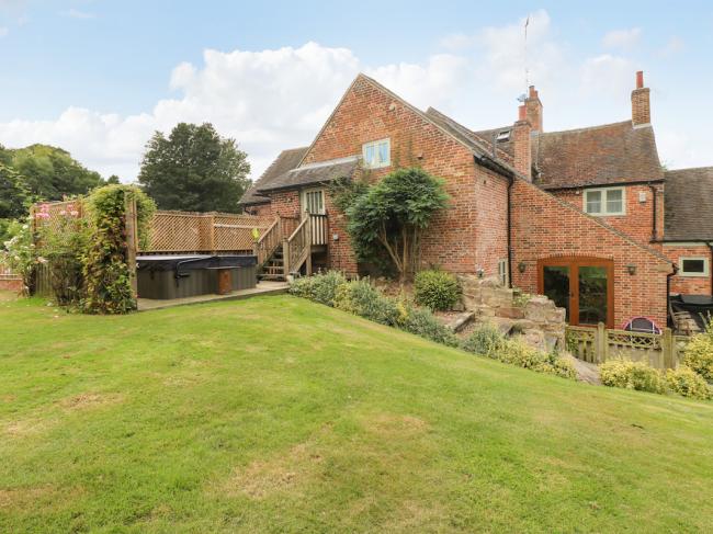 A large two-storey, Derbyshire split level farmhouse with terraces and a spacious lawn..