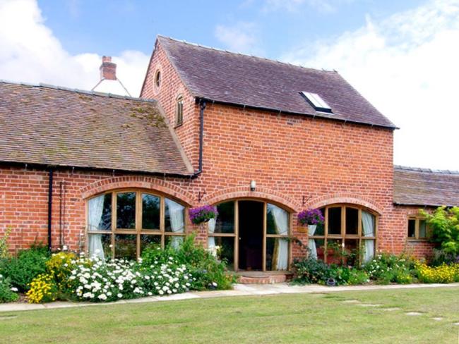A two-storey Shropshire barn conversion with arched floor-to-ceiling ground floor windows.