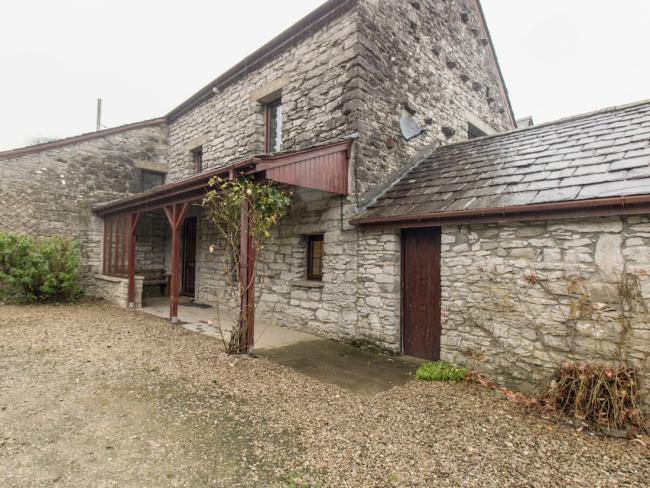 A stone, Cumbrian barn conversion in with a sheltered terrace overlooks a large parking space.