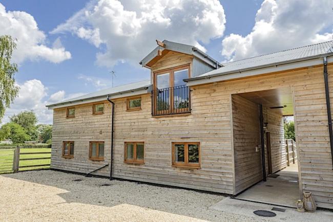 Exterior of a 2-storey wooden barn converted to a New Forest holiday cottage