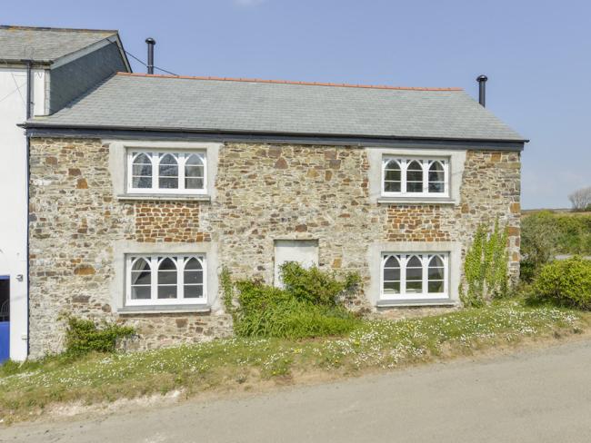 A double fronted stone-built North Devon country cottage with arched windows