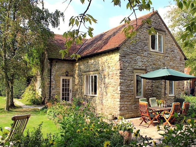 Stone-built Dorset farm cottage with a patio, lawns and mature trees.