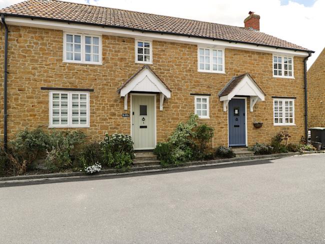 A semi-detached stone-built holiday cottage in Chideock overlooks a quiet village lane.