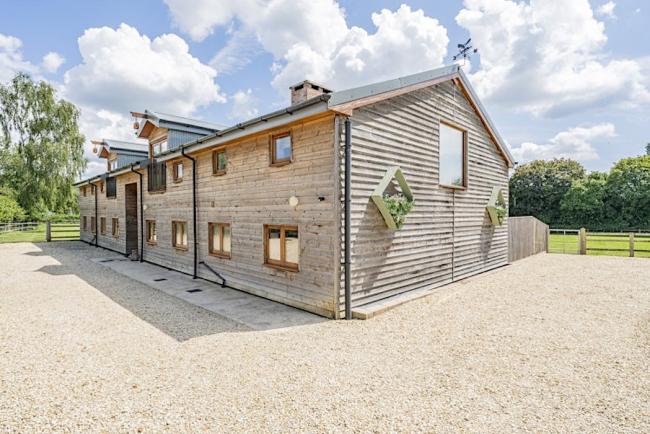 Exterior of a contemporary wood-clad barn conversion comprising 3 New Forest holiday cottages