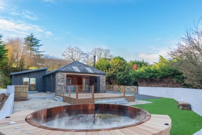  single-storey South Devon barn conversion overlooks a courtyard and a hot tub