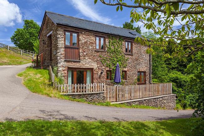 Exterior of an Exmoor Barn conversion on a bend in an empty country lane.