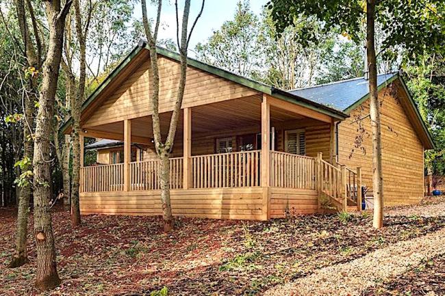 Exterrior of an eco lodge with a  covered deck and hot-tub.