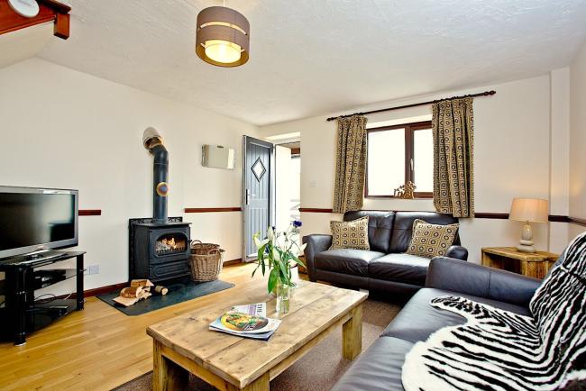A spacious lounge with sofas, woodburner and coffee table