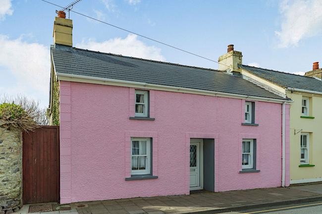 A double-fronted Pembrokeshire holiday cottage overlooks a quiet lane.