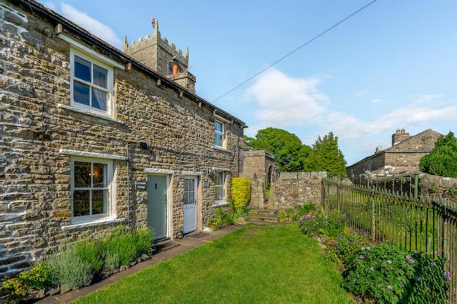 Terraced village cottages overlook a continuous front lawn.