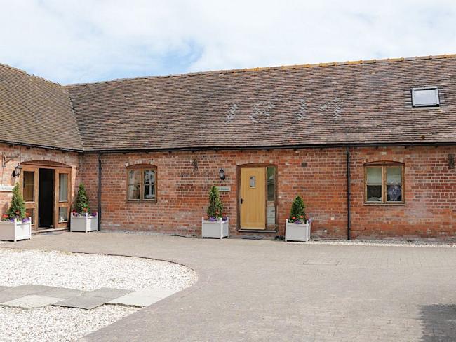 Exterior of a slate-roofed barn conversion overlooking a courtyard in Shropshire.