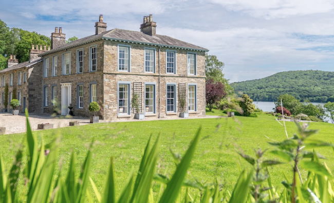 Exterior  of a country house in the Lake District with a lake in the background.
