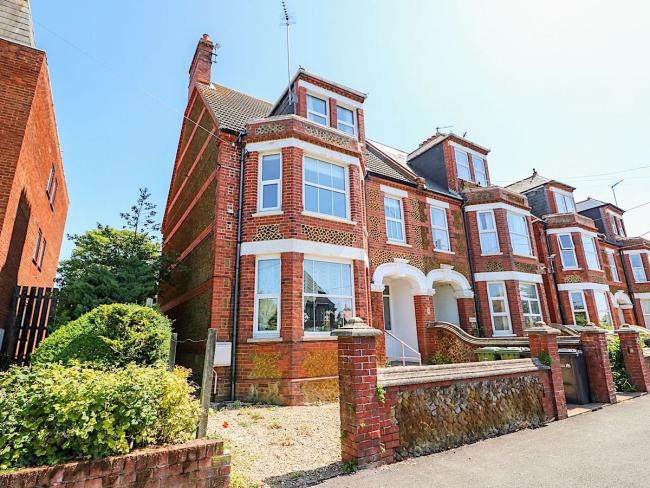 End of terrace exterior with off-road parking of a seaside holiday home in Hunstanton.