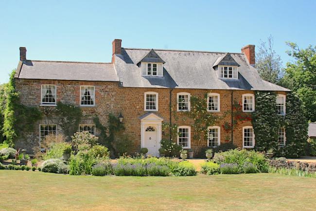 A large old Northamptonshire rectory looks out over flowerbeds and a spacious lawn.