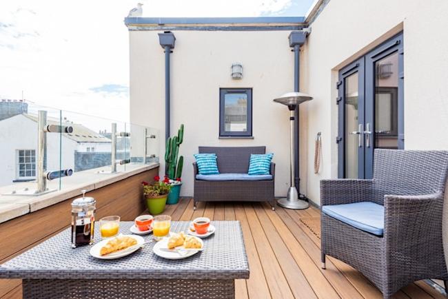 A Weymouth apartment deck with a table laid for breakfast.