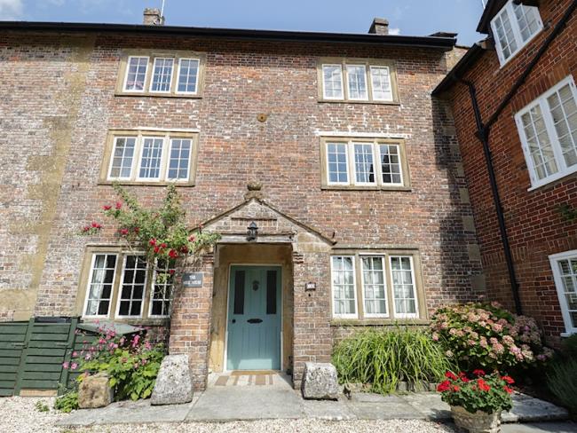 A 3-storey, brick-built, Dorset Mill House overlooks a cobbled courtyard.