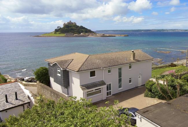 A large contemporary holiday home overlooks a beach and St. Michaels Mount in Cornwall