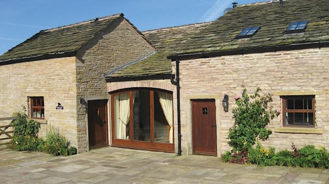 Exterior of a single-storey, stone-built, Cheshire holiday cottage.