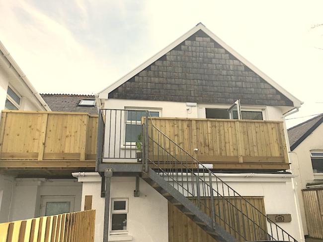2-storey gable end of a holiday apartment block with stairs and balconies.