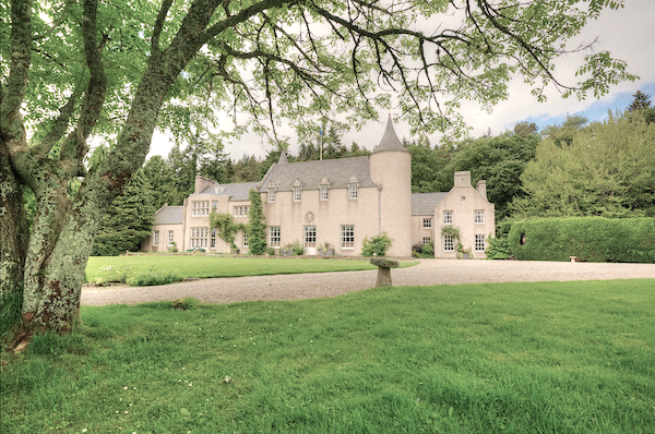A Highland Country House surrounded by wooded parkland.