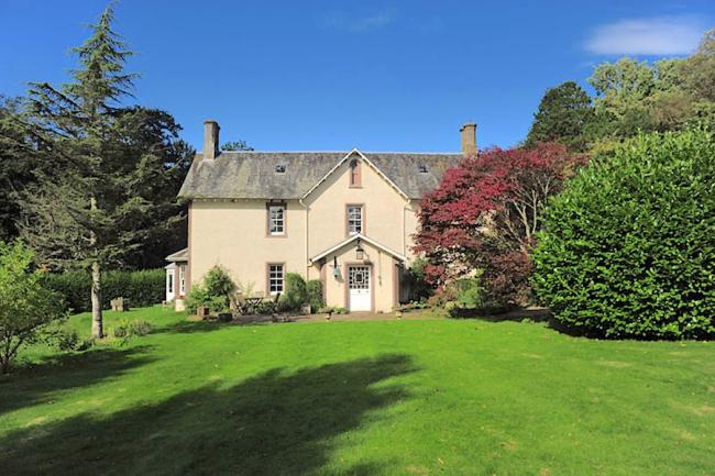 Exterior of a Scottish Manse overlooking s large tree-line lawn