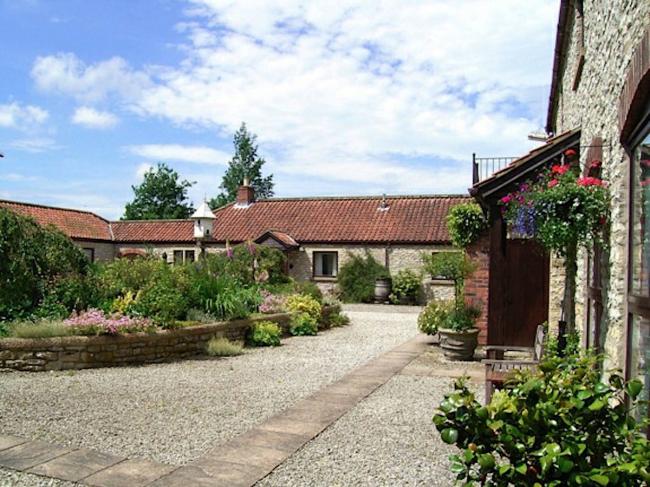Barn conversions overlook a courtyard with a central flower bed