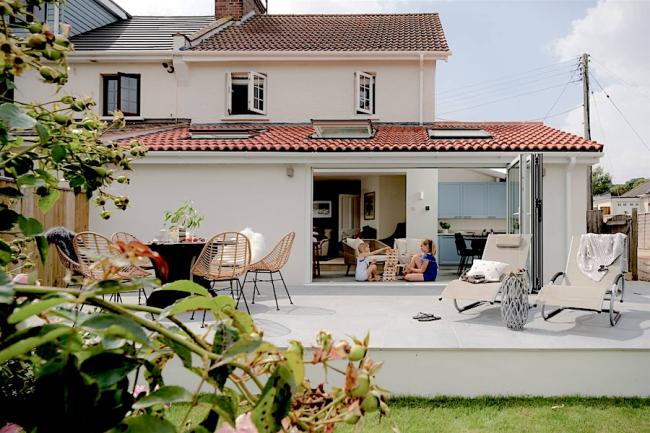 Exterior of a 2-storey contemporary home with twin floor-to-ceiling French windows opening onto the garden.