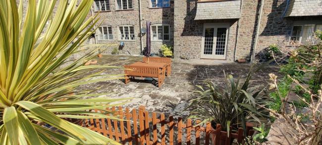 Stone-built exterior of an Exmoor country house and its courtyard garden.